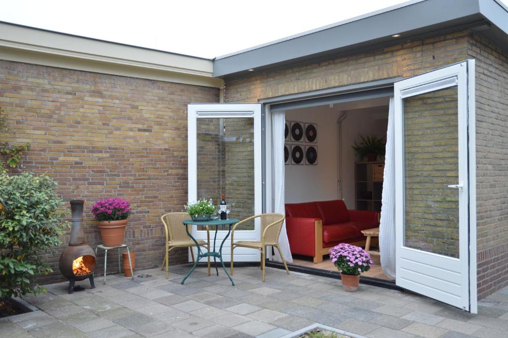 a patio with a sliding glass door with a table and chairs at Cosy Casa in Egmond aan Zee
