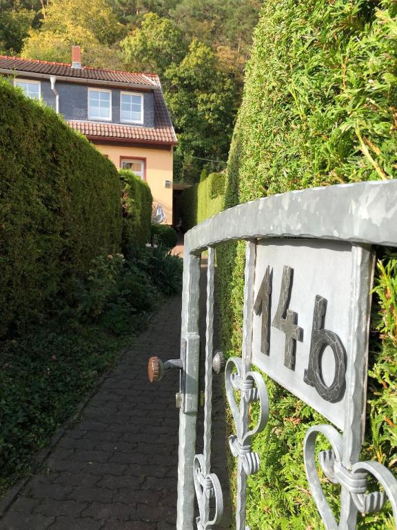 a house with a sign that says on a hedge at Ferienwohnung Harzerfuchs in Wernigerode