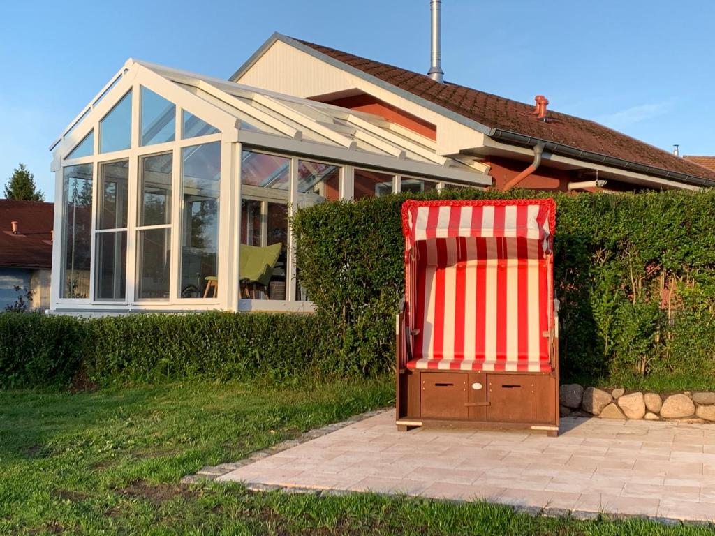 a large red and white chair in front of a house at Ferienhaus am Nationalpark - Ihr Zuhause auf Rügen in Lohme