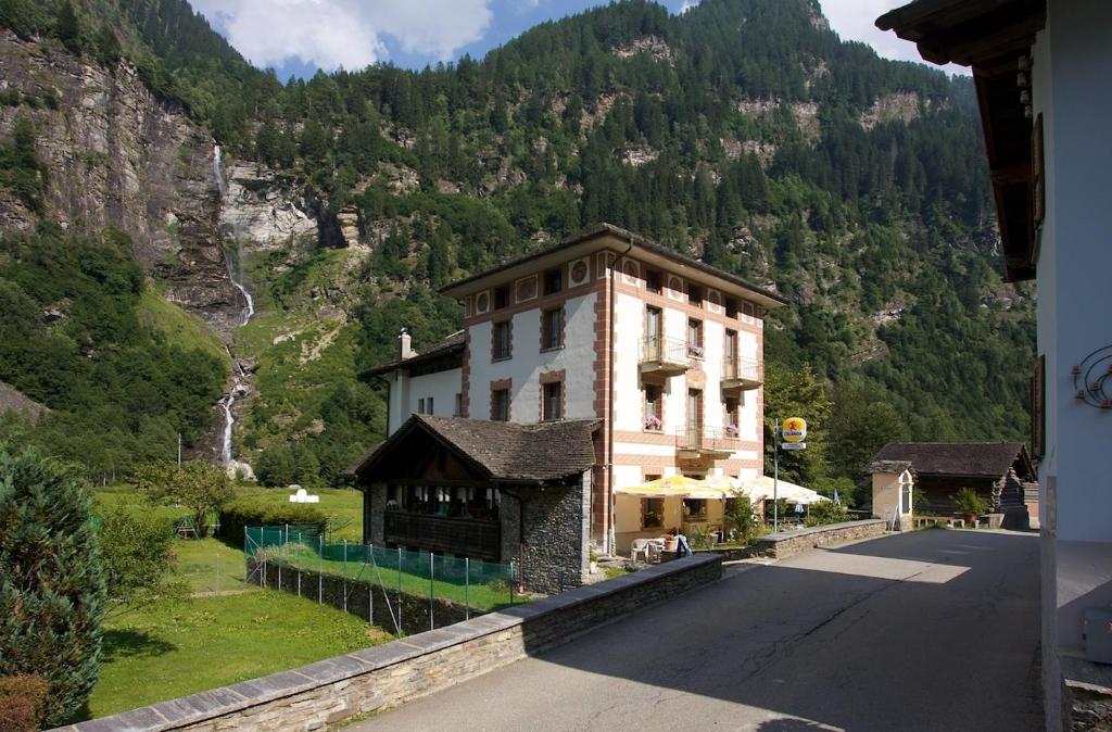 un edificio al lado de una carretera junto a una montaña en Hotel La Cascata en Rossa