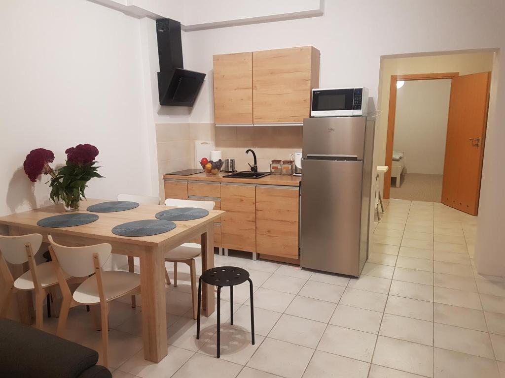 kuchnia ze stołem i lodówką ze stali nierdzewnej w obiekcie Apartamenty i pokoje Pluszak w mieście Sandomierz