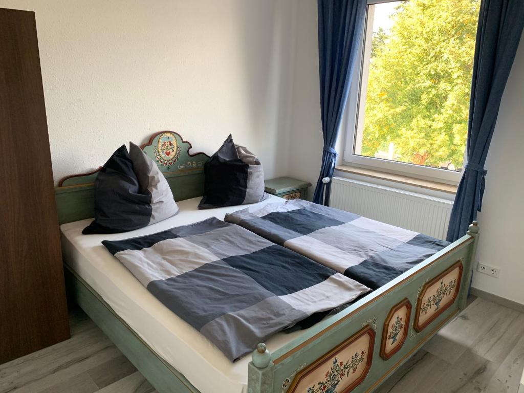 Bett in einem Schlafzimmer mit Fenster in der Unterkunft Apart-Hotel Rheinischer Hof Dormagen in Dormagen