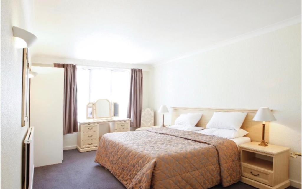 a hotel room with a bed and a window at MAYFAIR PRIME APARTMENTS in London