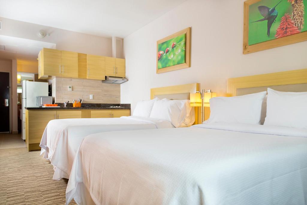 Postel nebo postele na pokoji v ubytování Excellence Express & Suites