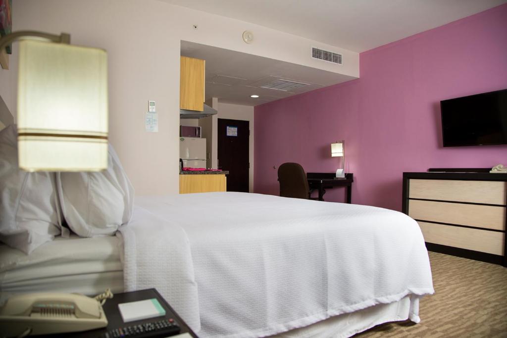 Postel nebo postele na pokoji v ubytování Excellence Express & Suites