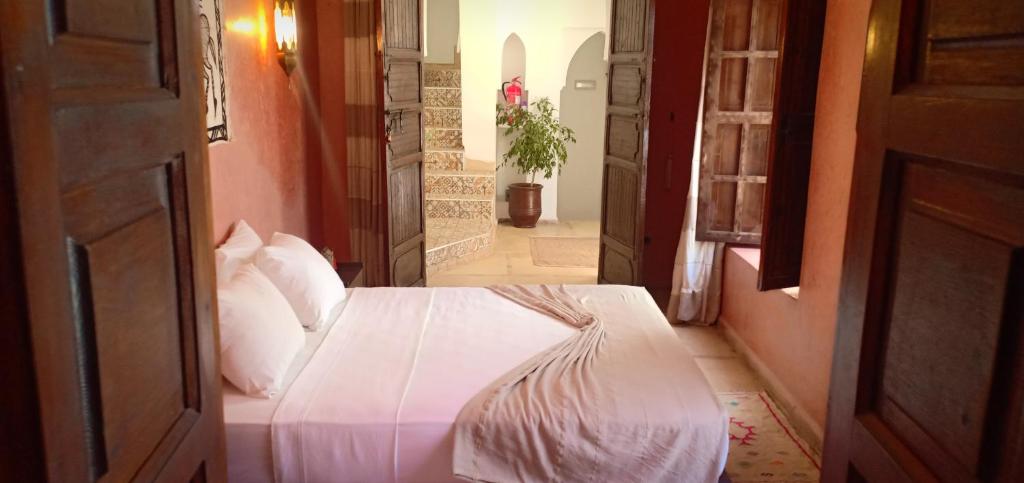 1 dormitorio con 1 cama blanca en el pasillo en Riad Safia en Marrakech