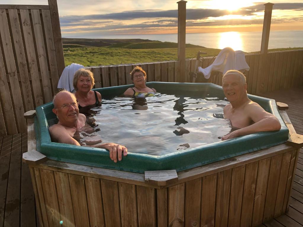 um grupo de pessoas numa banheira de hidromassagem em Guesthouse Gimbur em Reykjarholl