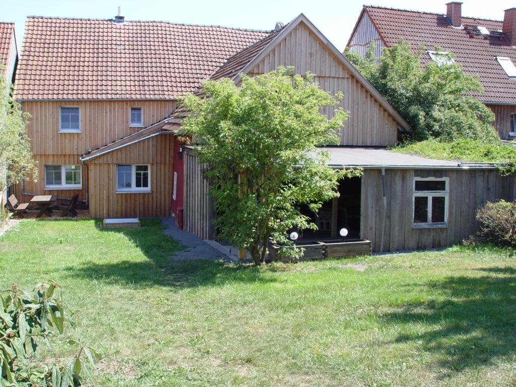 una casa de madera con un patio con un árbol en Ferienhaus Kaline, en Grebenhain