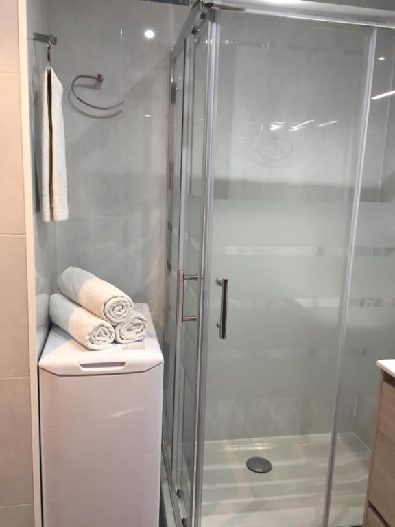 a shower with a glass door next to a toilet at Pineda Beach PORT AVENTURA in La Pineda