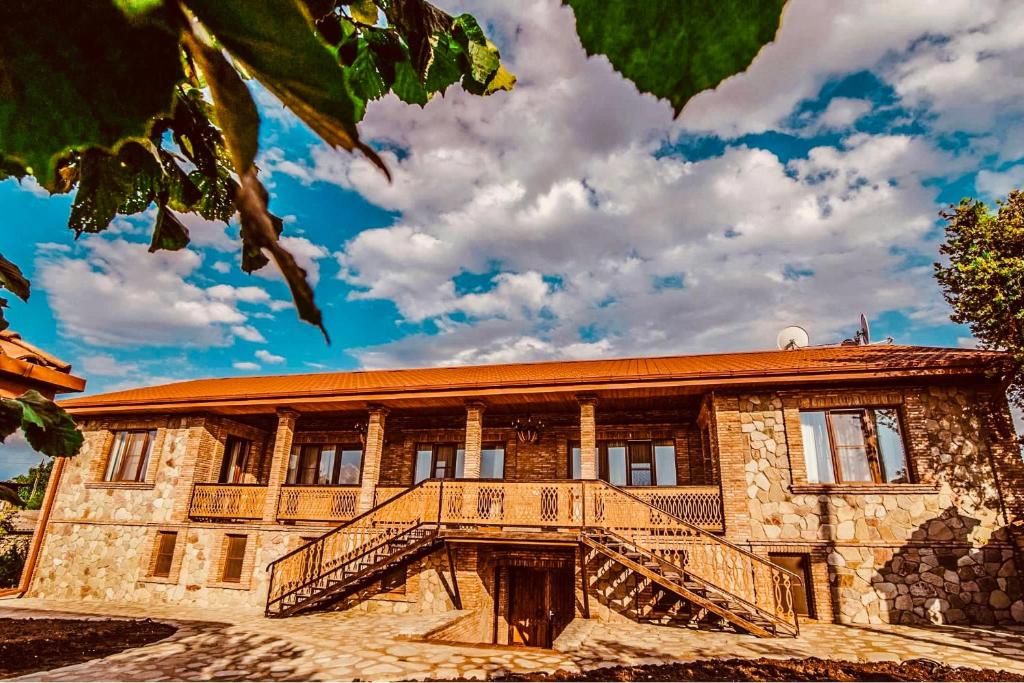 a building with a staircase in front of it at Galaktioni's Marani in Kondoli