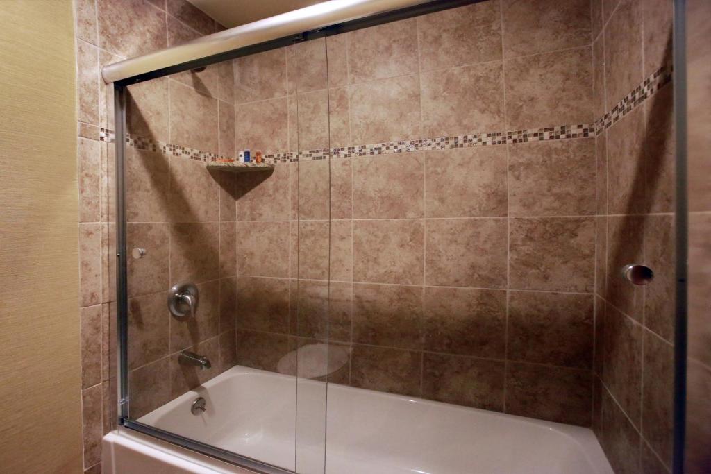 a shower with a glass door and a tub at The Claridge Hotel in Atlantic City