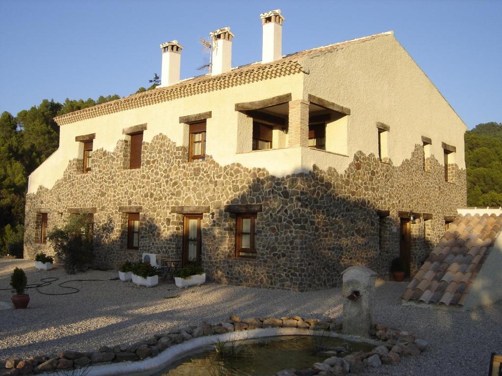 een groot stenen gebouw met een fontein ervoor bij Casa Rural Cortijo La Ajedrea in Siles