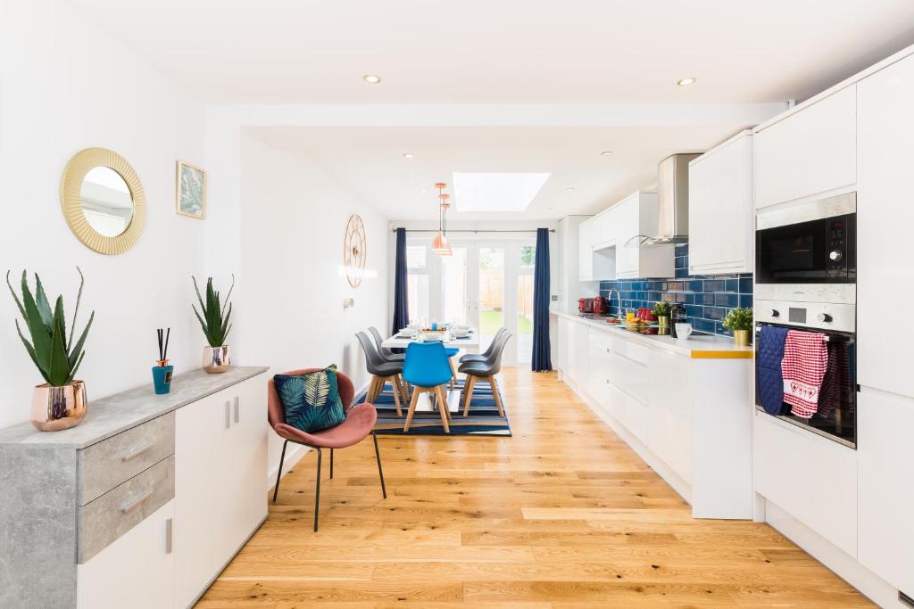 a kitchen with white cabinets and a table with chairs at Goode House by Svelte Living in Birmingham