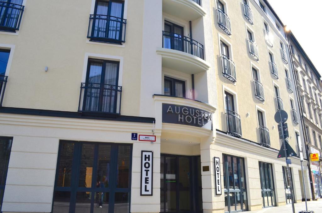 un grand bâtiment blanc avec un panneau indiquant un hôtel dans l'établissement Augusten Hotel München, à Munich