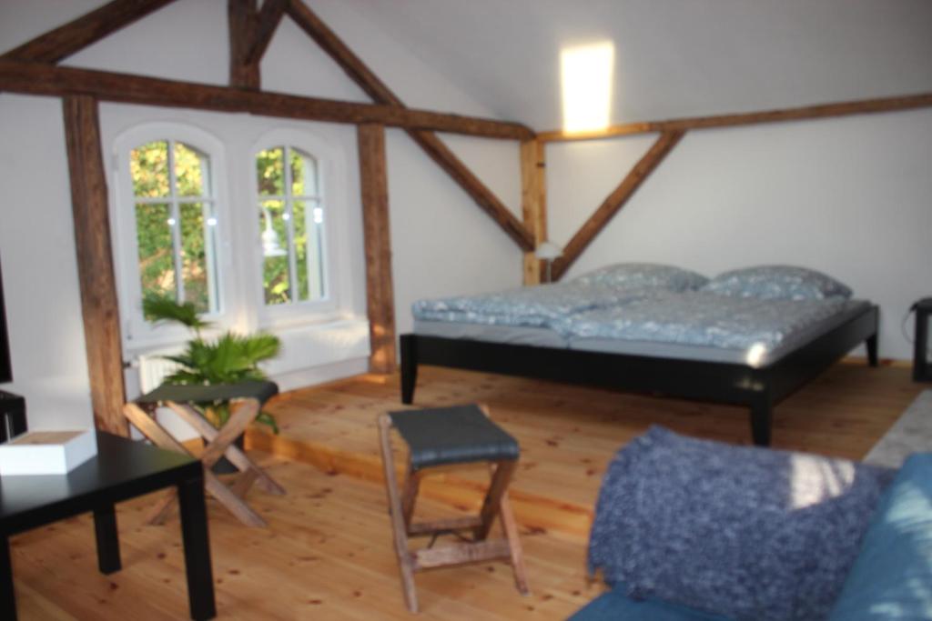 a living room with a bed and a chair at Ferienwohnung Goldgrund Gartenblick in Meißen