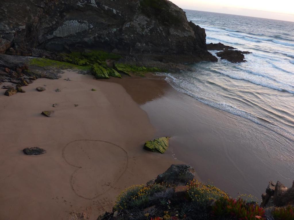 an aerial view of a beach with a person drawn in the sand at Bohemian Antique Guesthouse in Odeceixe