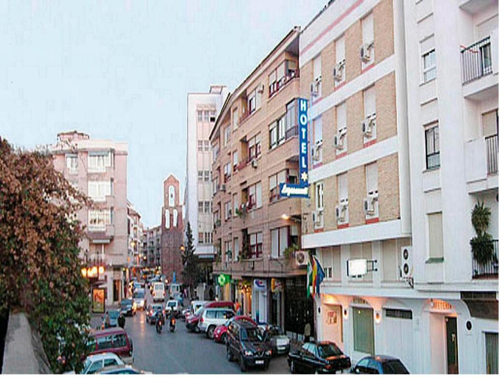 a busy city street with cars parked on the street at Hotel Restaurante Logasasanti in Andújar