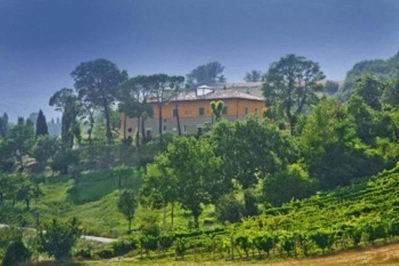 Relais Villa Fornari في كاميرينو: منزل على قمة تل به اشجار
