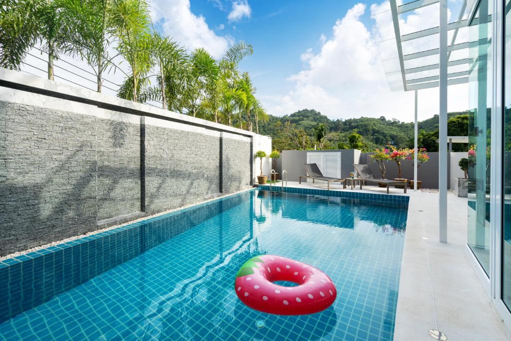 ein Schwimmbad mit einer Poolnudel in der Mitte in der Unterkunft Villa Kamala close to the beach in Kamala Beach