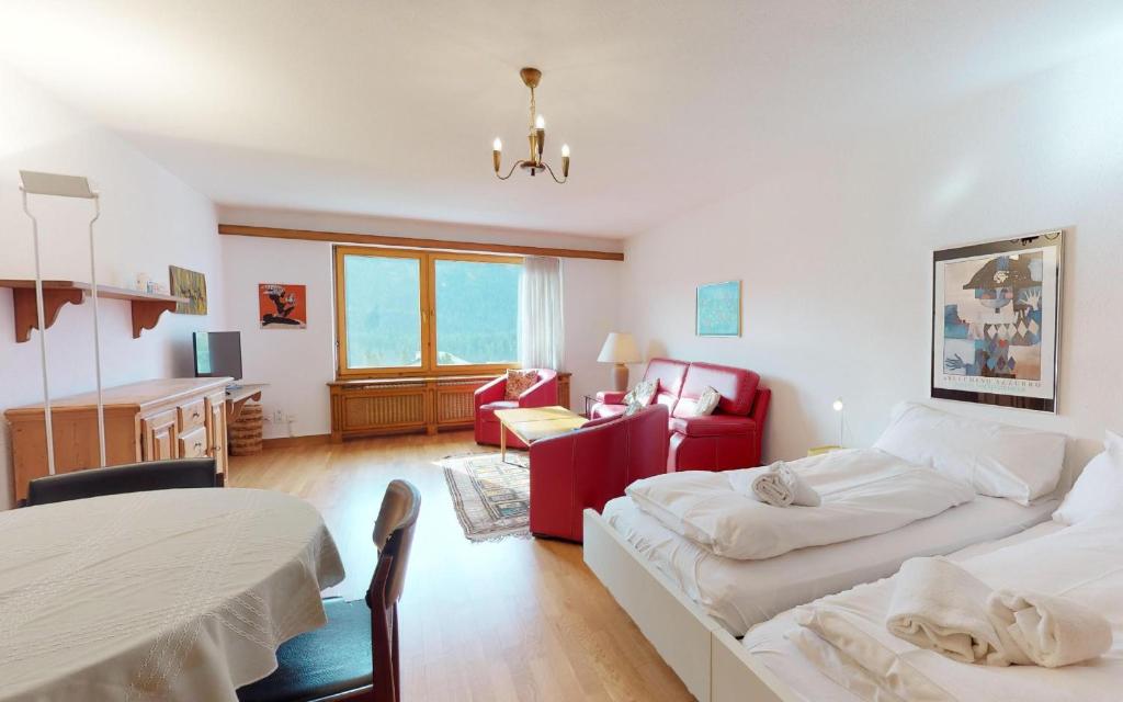 um quarto com 2 camas e uma sala de estar em Suot Brattas 21 em St. Moritz
