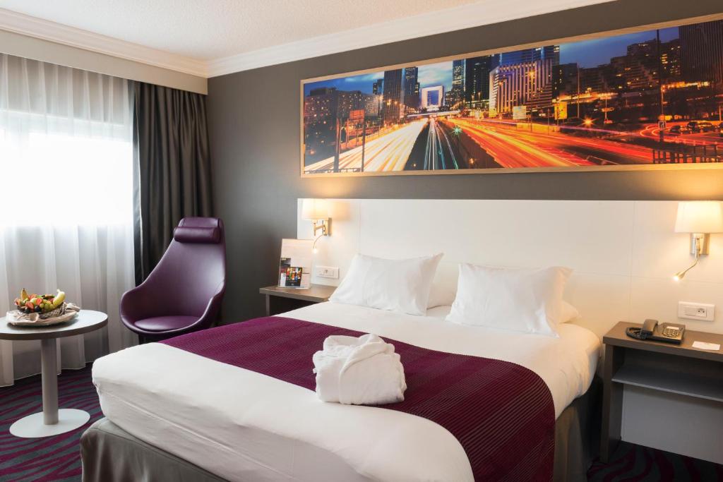 a hotel room with a large bed and a tv at Best Western Plus Paris Orly Airport in Rungis