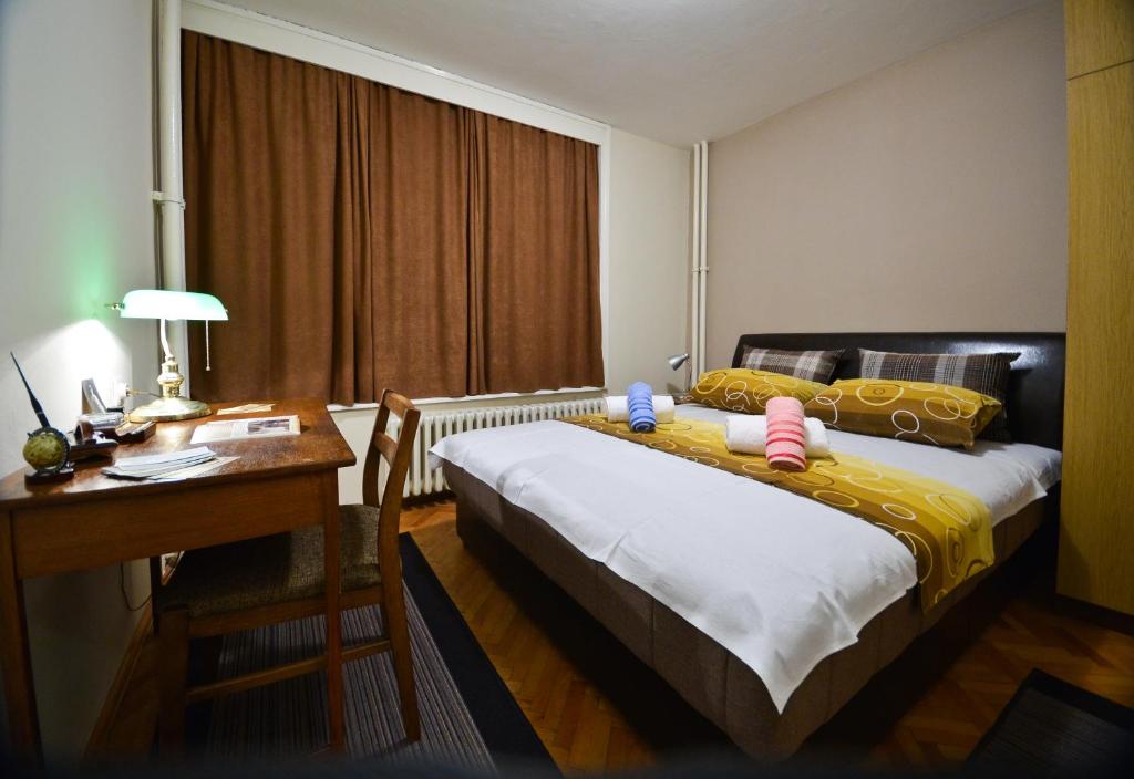 a hotel room with a bed and a desk and a desk at Glorious Rooms in Niš