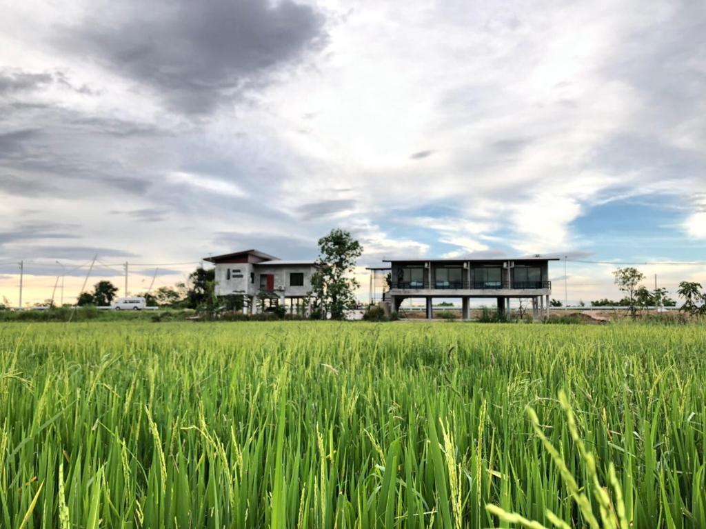 una casa en medio de un campo en Ban Suweena, en Uthai Thani