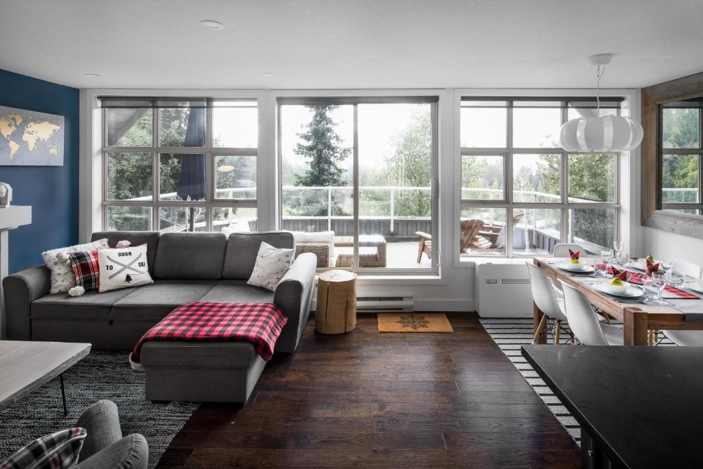 uma sala de estar com um sofá e uma mesa em THE LOOKOUT PENTHOUSE // a luxe suite in Whistler em Whistler