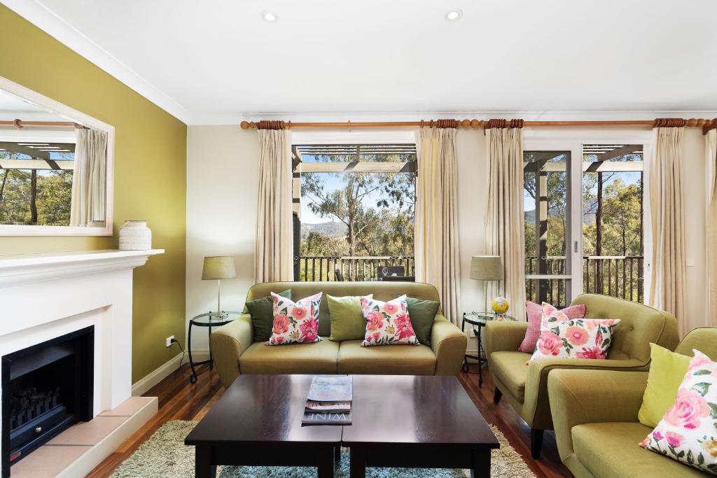 a living room with two couches and a fireplace at Villa Cabernet in Pokolbin