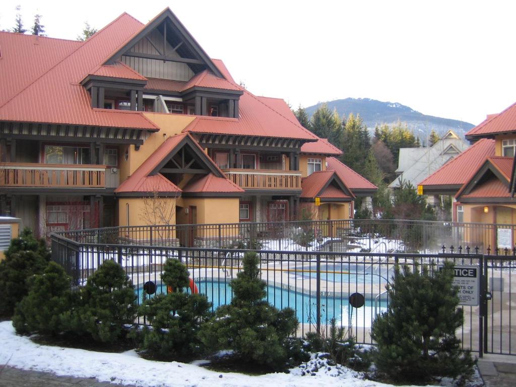 惠斯勒的住宿－Sunpath Condos by Whistler Retreats，一座带游泳池的度假村,位于一座建筑前