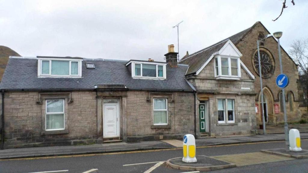 une vieille maison en briques sur le côté d'une rue dans l'établissement Carvetii - Gemini House - 4 bed House sleeps up to 8 people, à Tillicoultry