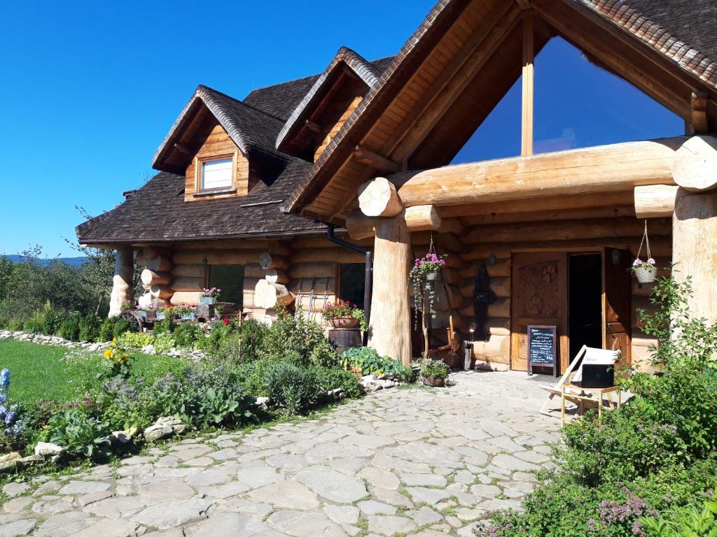 drewniany domek z kamiennym patio przed nim w obiekcie Wilcza Jama - domki z bali w mieście Lutowiska