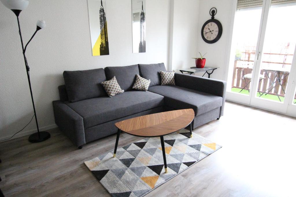 a living room with a couch and a table at Colmar City Center - SCHNAPSALA Terrasse and Free Parking - BookingAlsace in Colmar