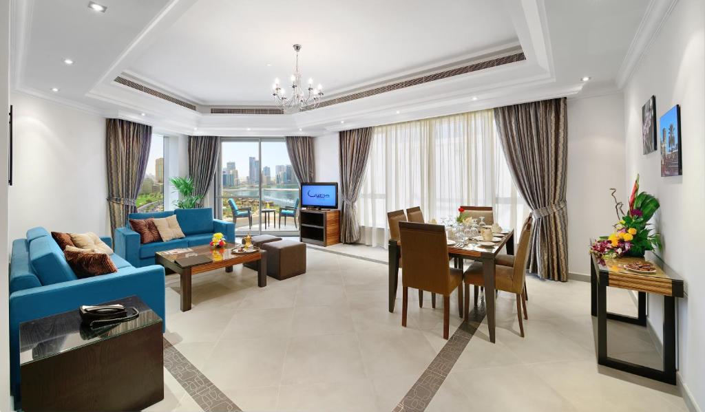 a living room with a blue couch and a table at Al Majaz Premiere Hotel Apartments in Sharjah