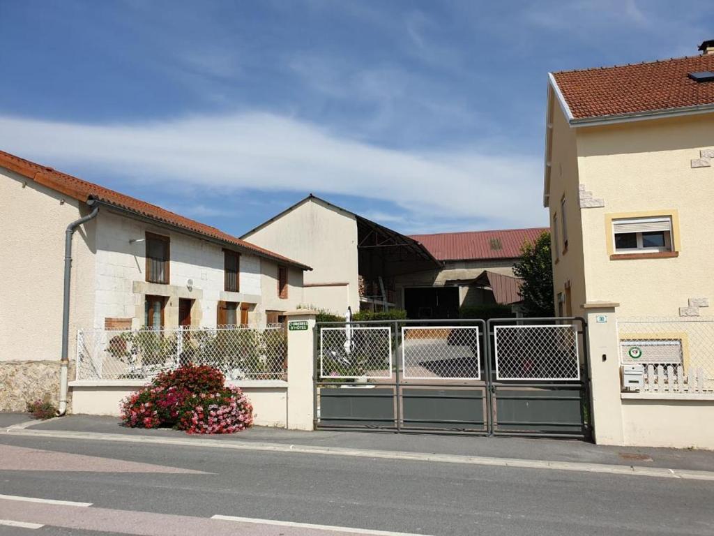 a fence on the side of a street next to houses at COUR LA DAME chez Béatris et Christophe Janson in Les Grandes-Loges