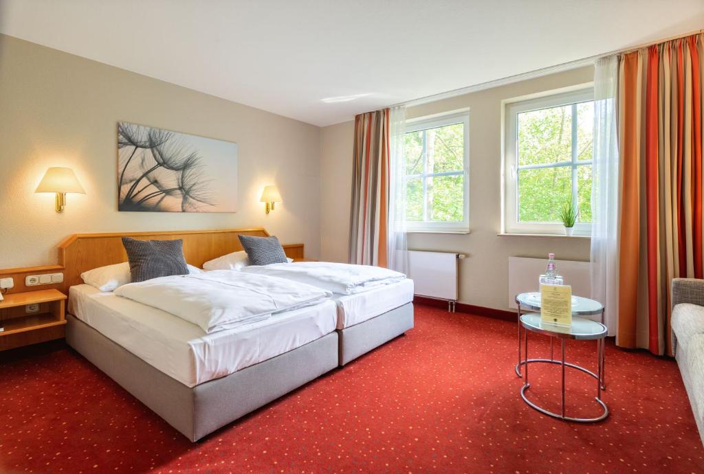 ein Hotelzimmer mit einem Bett und einem Tisch in der Unterkunft Parkhotel Diani in Leipzig