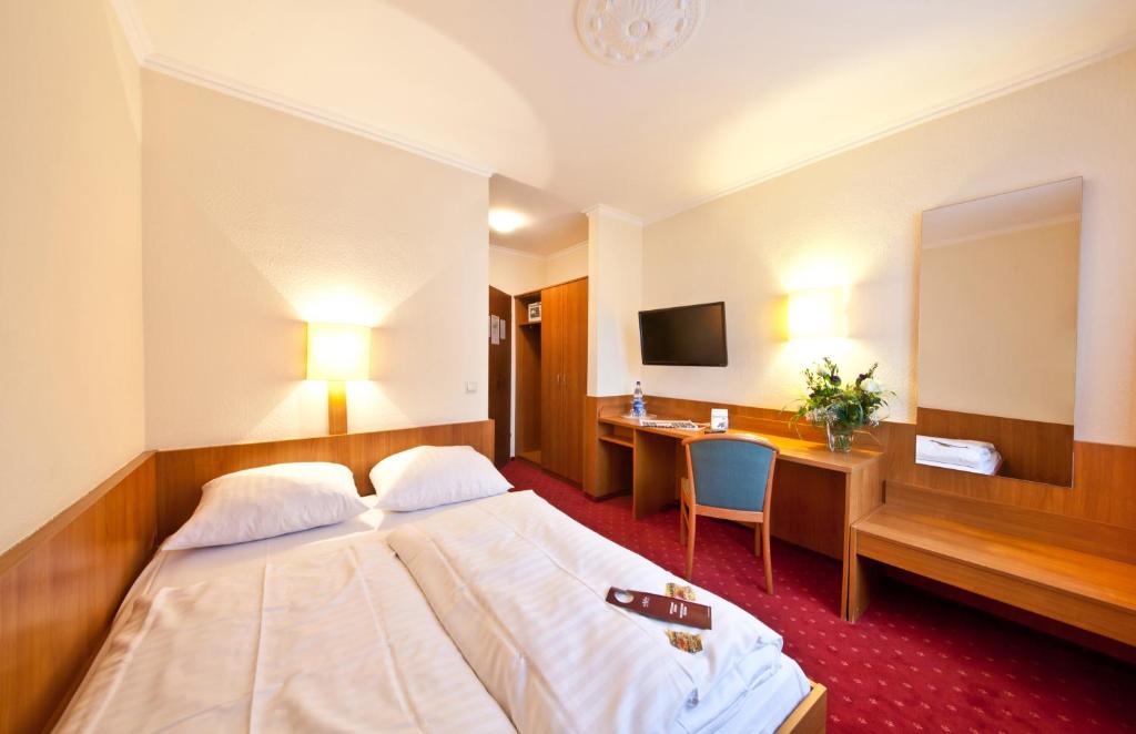 フランクフルト・アム・マインにあるホテル プリムス フランクフルト ザクセンハウゼンのベッドとデスクが備わるホテルルームです。