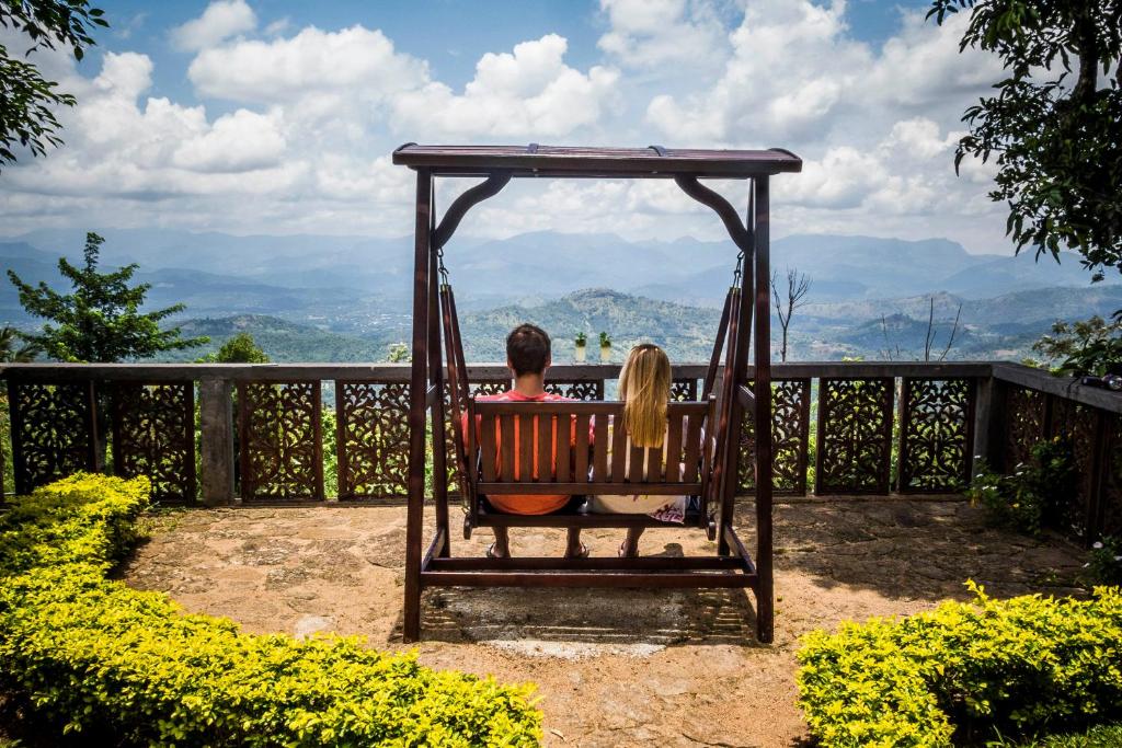 a man sitting on a bench in front of a fence at Galavilla Boutique Hotel & Spa in Kandy