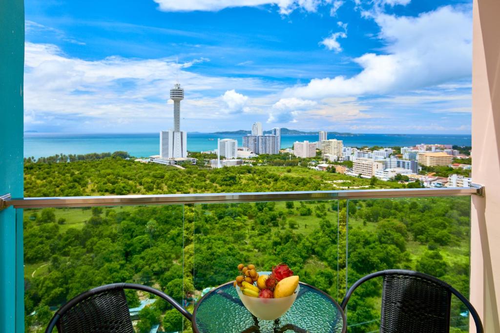 a bowl of fruit on a table with a view of a city at Grande Carribean sea view apartments Jomtien beach in Pattaya South