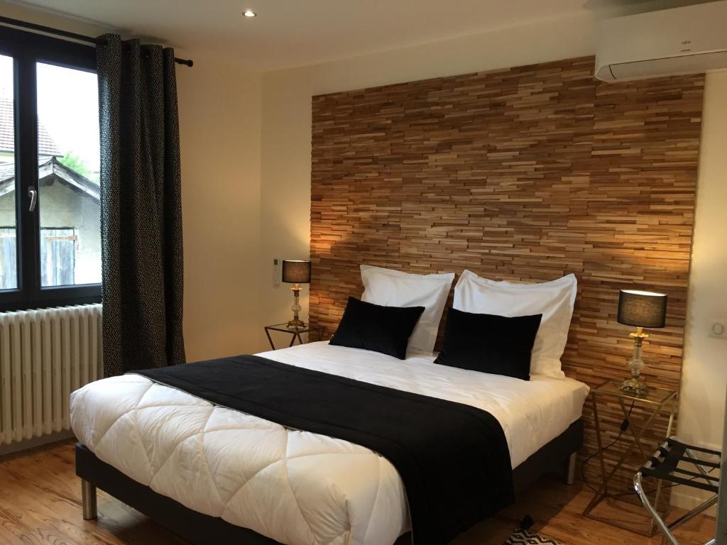 um quarto com uma cama grande e uma parede de tijolos em LA PORTE DES ALPES em Barberaz