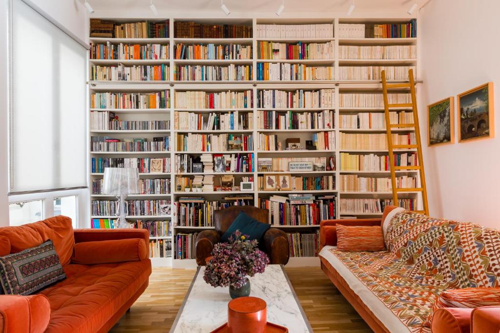 a living room with a large library with books at Veeve - The Library Wall in Paris