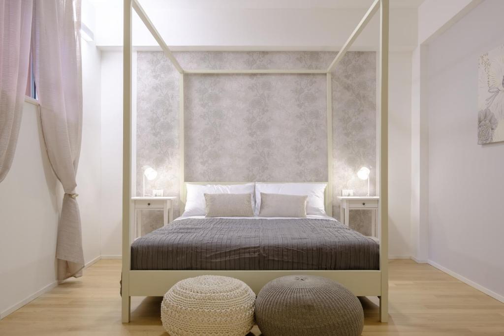 una camera con letto a baldacchino e pavimento in legno di Bologna House Tubertini Apartment a Bologna