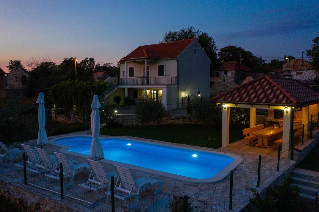 een zwembad voor een huis 's nachts bij Villa Ane, Divine holiday in Trbounje