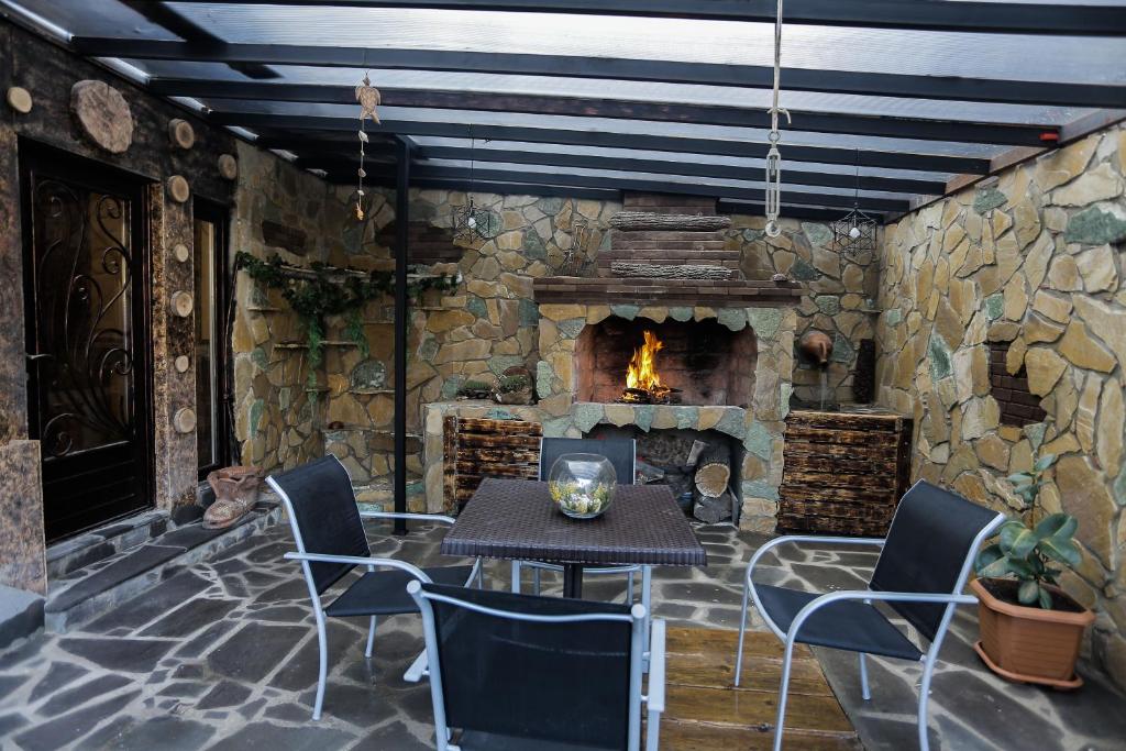 a patio with a table and a stone fireplace at SunnyAvlabari Homestay in Tbilisi City