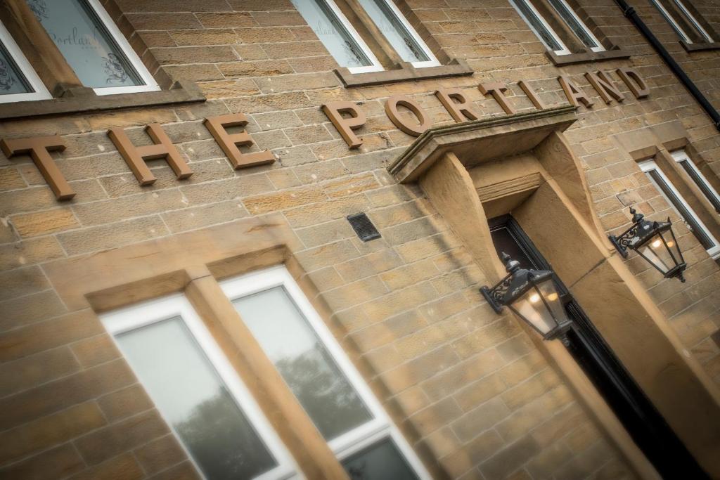 a sign on the side of a brick building with the words hotel at The Portland in Ashington