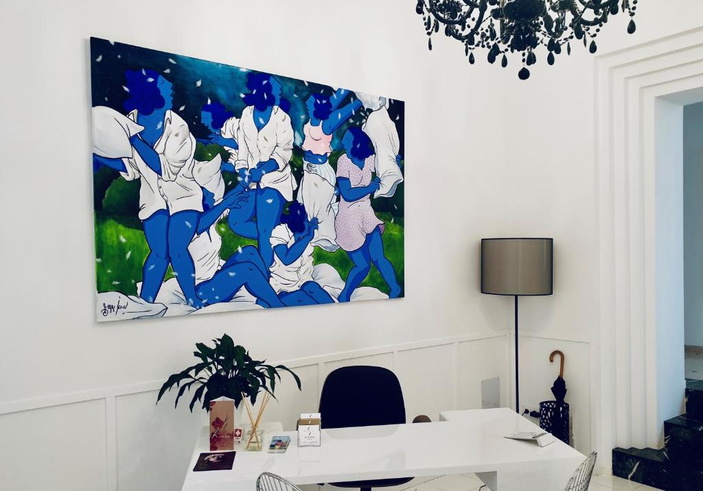 een schilderij aan de muur van een kamer met een bureau bij Divina Suites Hotel Singular -Adults Only in Ciutadella