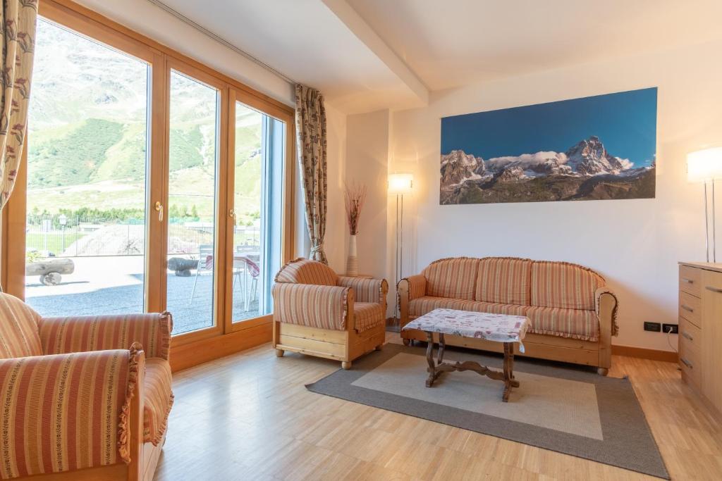 a living room with two chairs and a table at Monte Cervino Apartment AS21 in Breuil-Cervinia