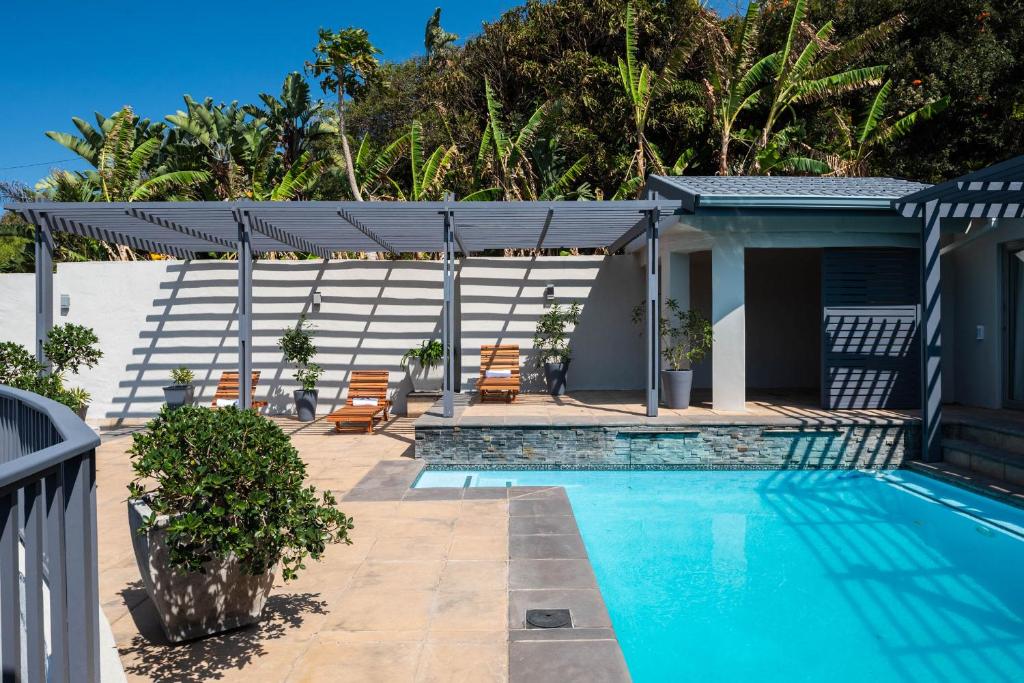 a swimming pool with chairs and a house at 5 On Lindsay in Durban