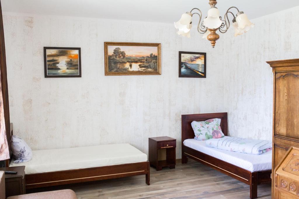 een kamer met 2 bedden en schilderijen aan de muur bij Agroturystyka Jaśmina in Warnice