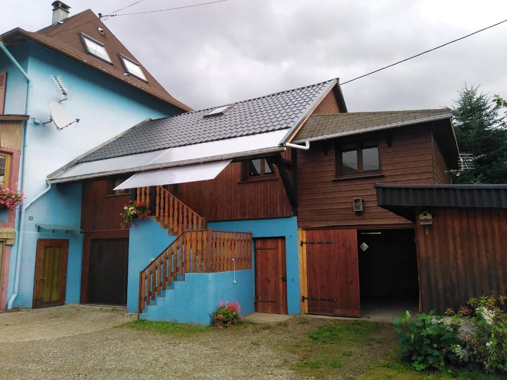 a blue and brown house with a garage at Meublé de tourisme in Oderen